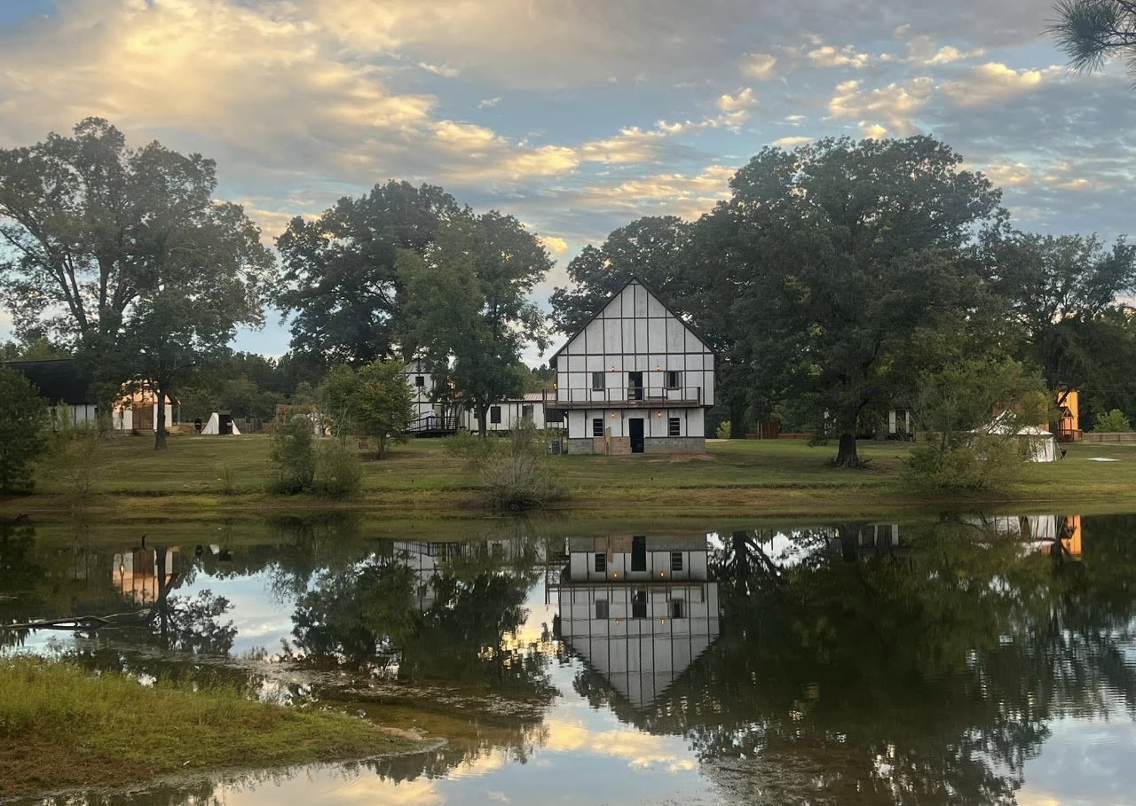 Dalwhinnie Fields building reflected in a pond at sunset.