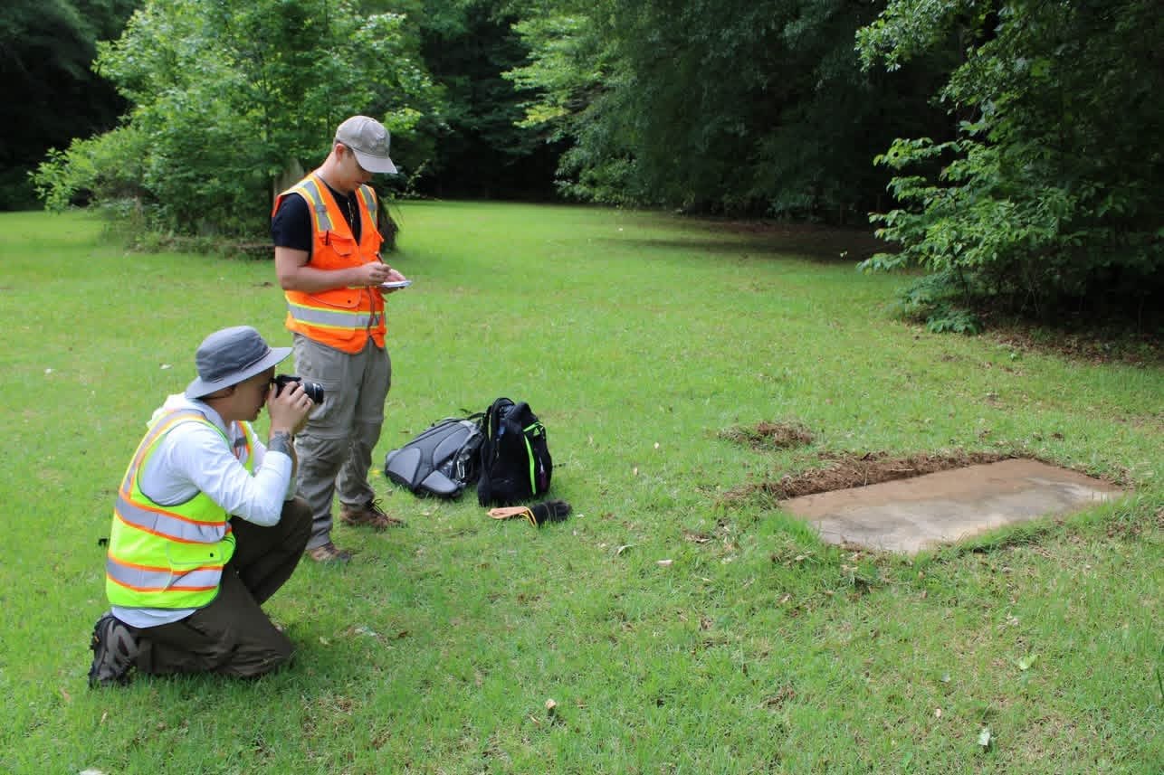 Participants photographing a grave feature at Capitol Cemetery for photogrammetric documentation