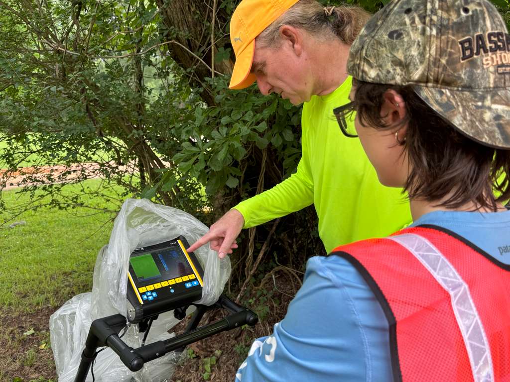 Participants reviewing a Ground Penetrating Radar (GPR) display in the field