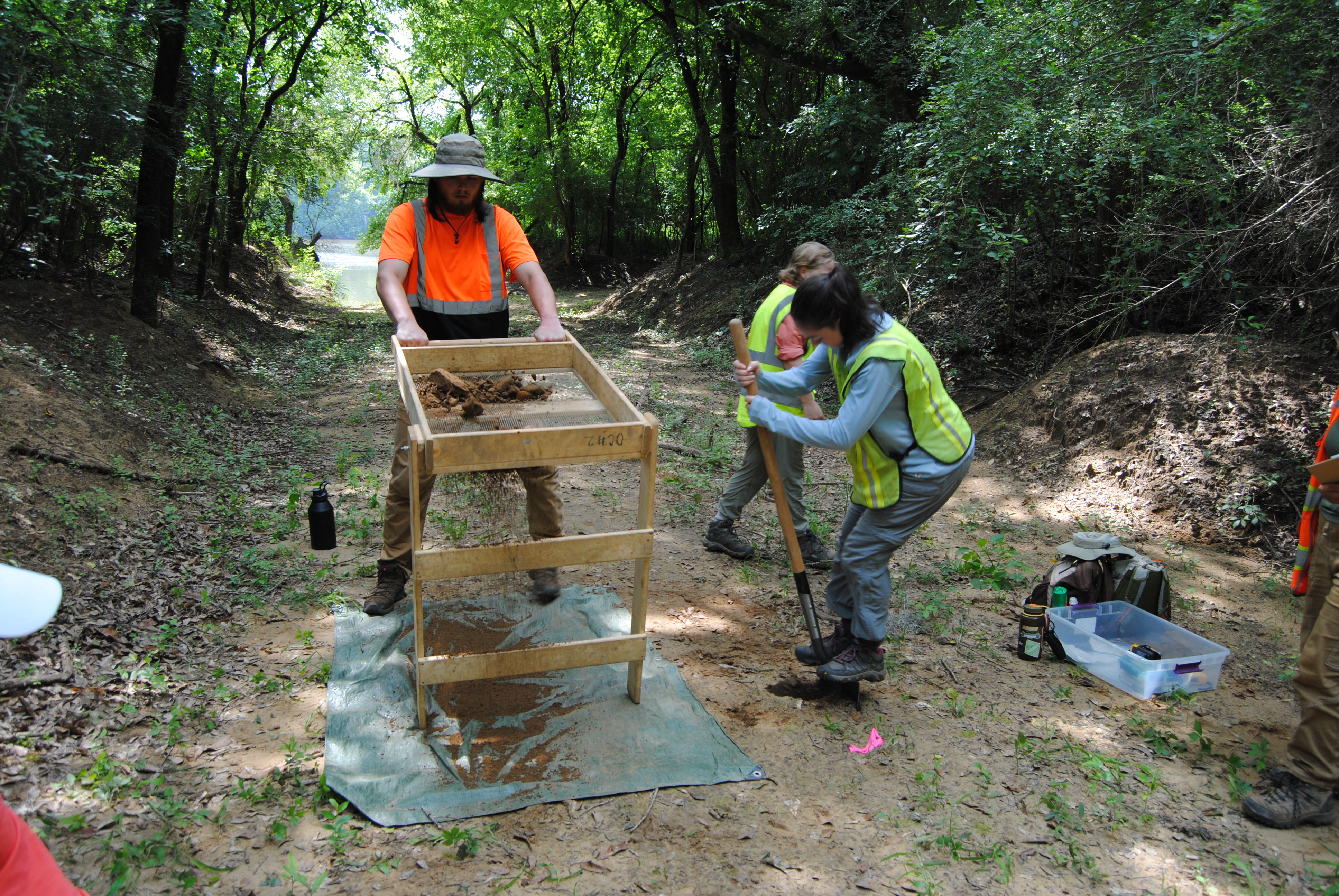 Participants screening excavated soil at a field site